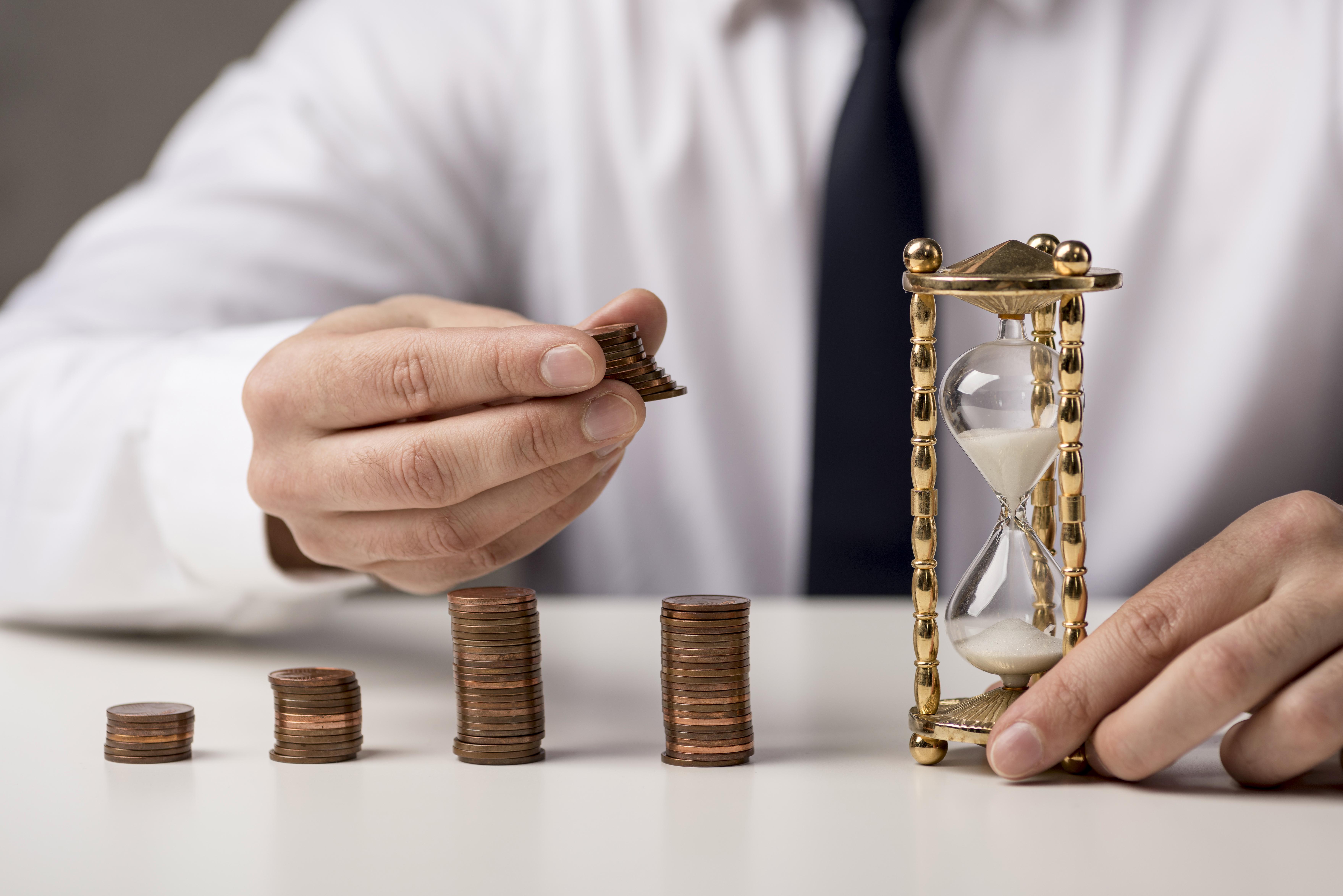 front view businessman with coins hourglass