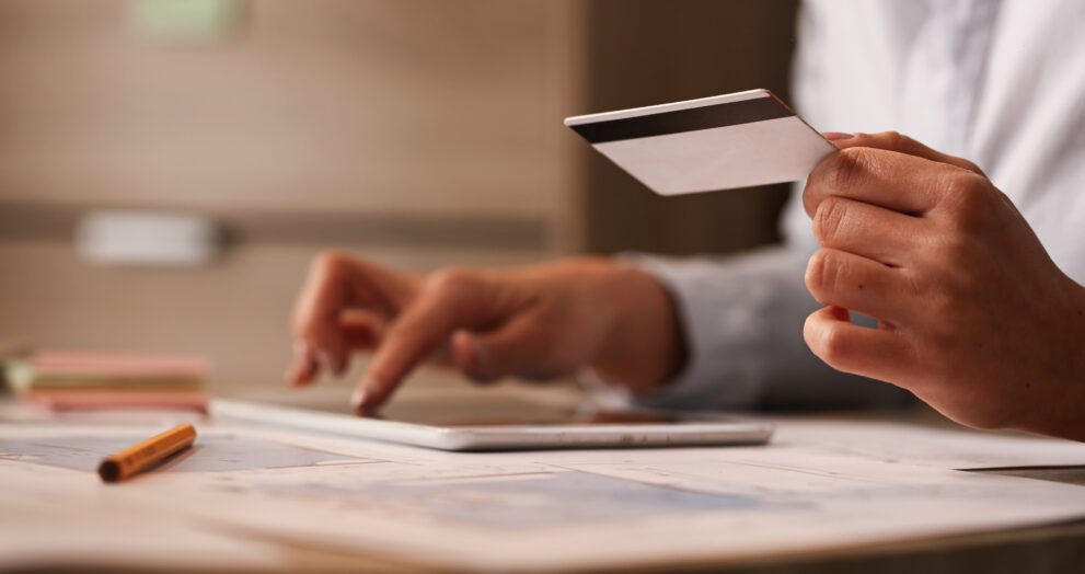 close up businesswoman with credit card checking her bank account digital tablet