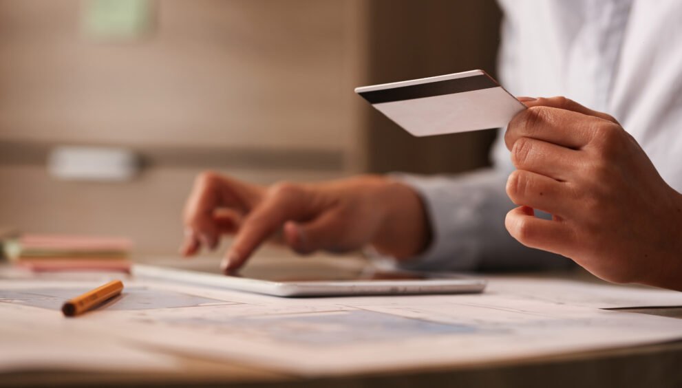 close up businesswoman with credit card checking her bank account digital tablet