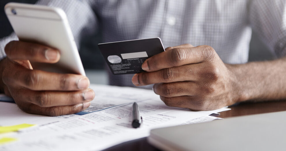 african man shirt paying goods internet using credit card cell phone