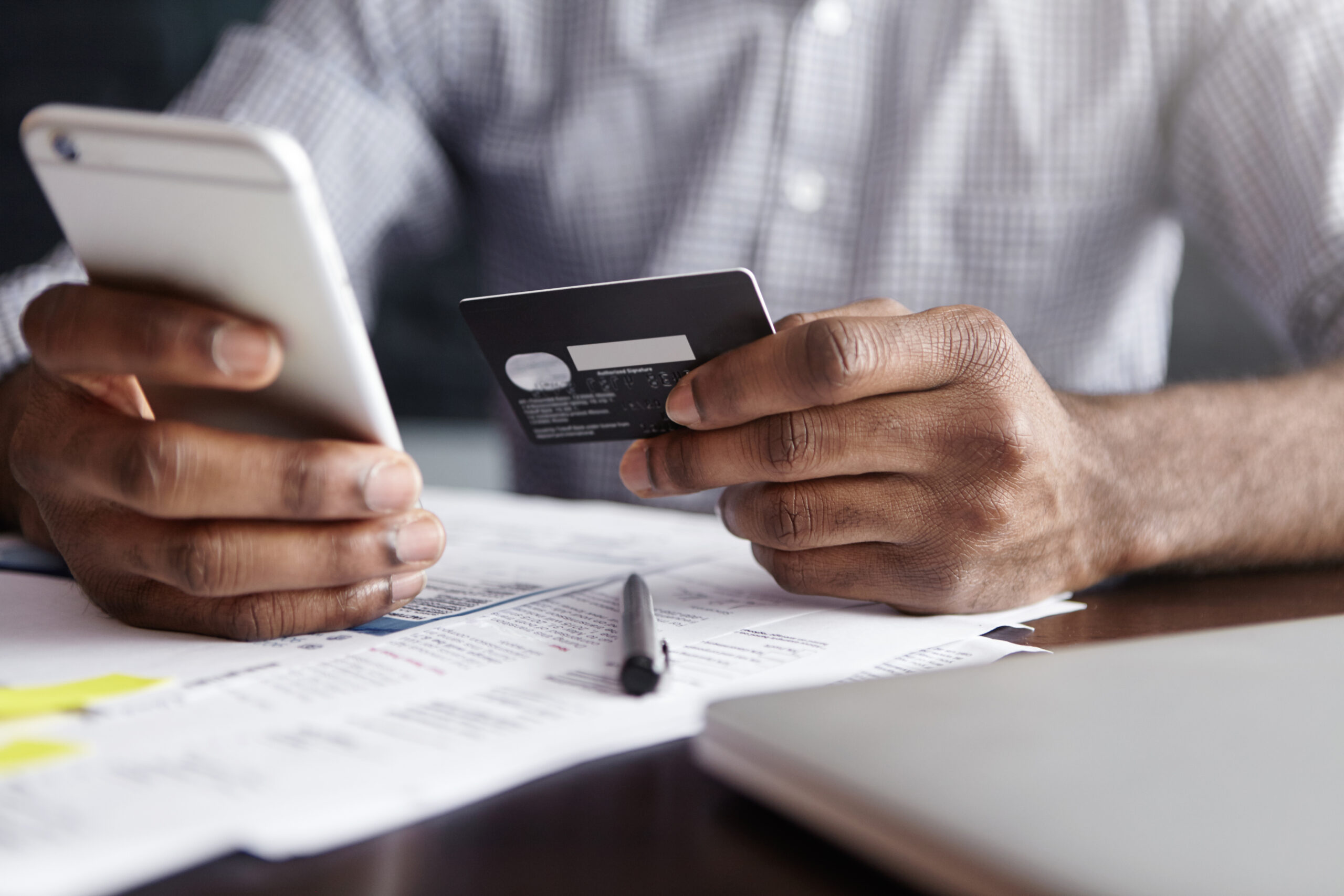 african man shirt paying goods internet using credit card cell phone scaled