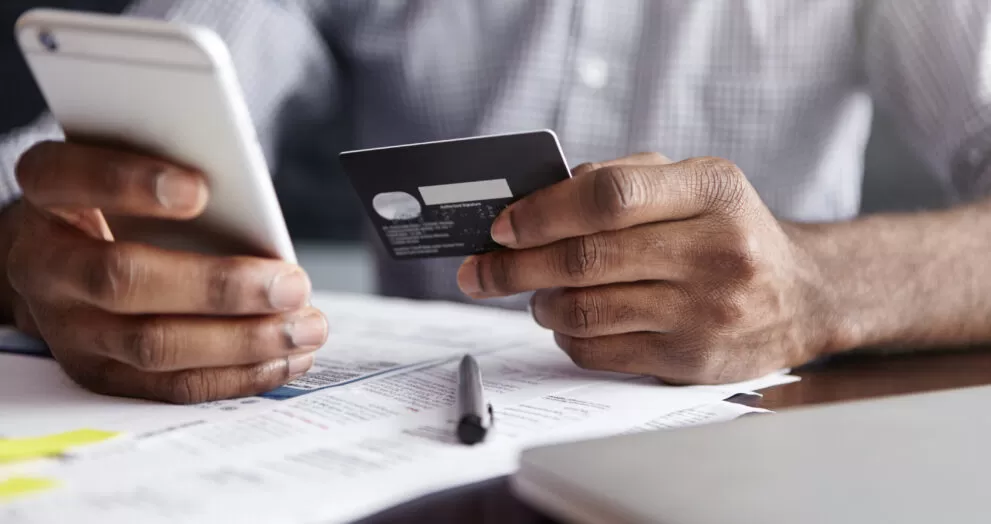 african man shirt paying goods internet using credit card cell phone